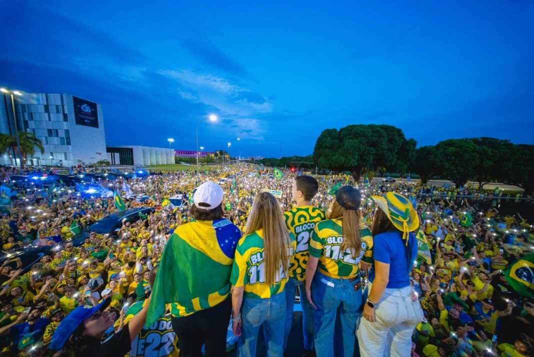 sob-luzes,-apoiadores-de-flavio-e-celina-cantam-hino-nacional-em-ato-no-df